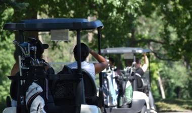Photo of women riding in golf cart on golf course