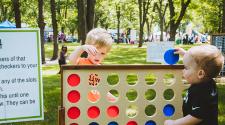 This image shows two boys playing giant, yard sized checkers at Midwest Kids Fest.