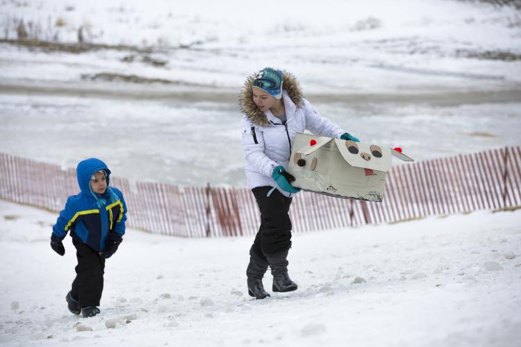 This image shows two kids walking up the hill at the 2017 Cardboard Sled Race