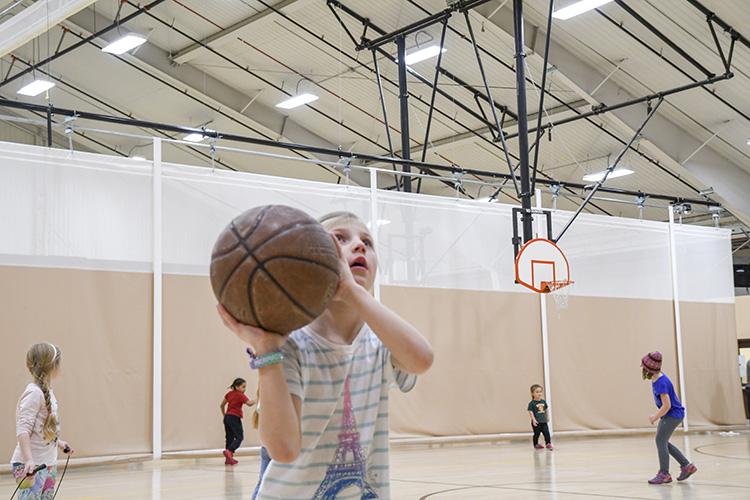 basketballyouth1 This image shows a girl shooting a basketball at the youth basketball program.