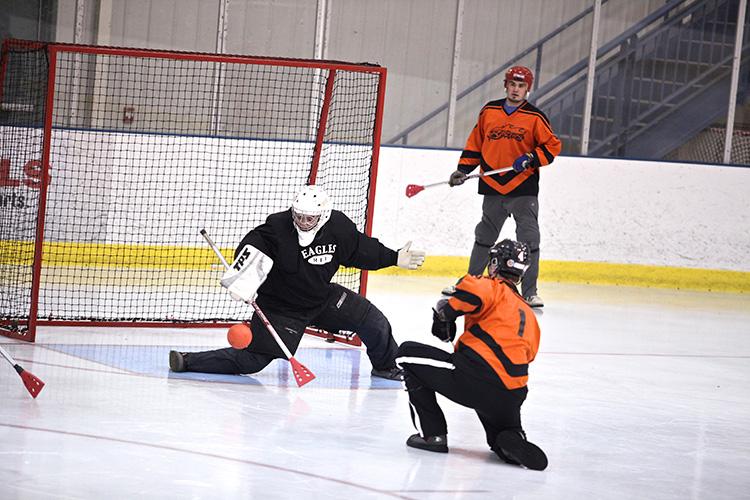 broomballadult3 This image shows the goalie stopping a shot during adult broomball.
