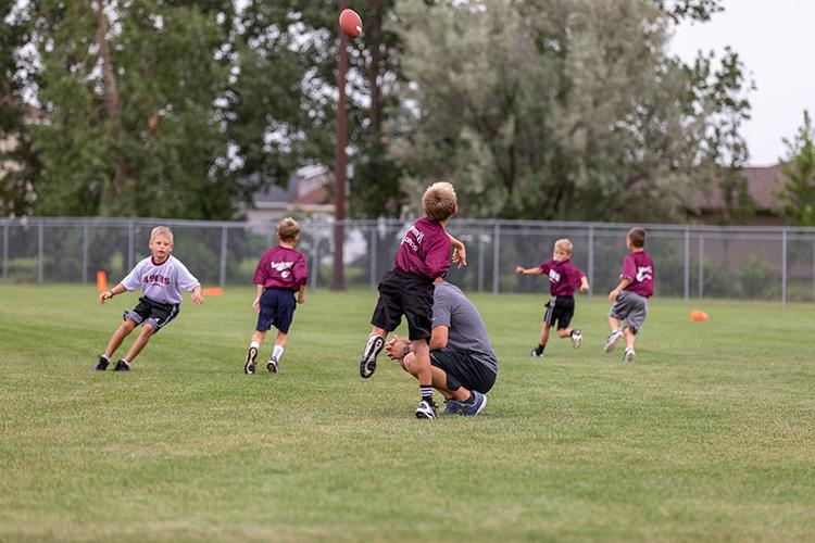 flagfootballyouth This image shows a boy throwing the football to his teammates at the youth football program.