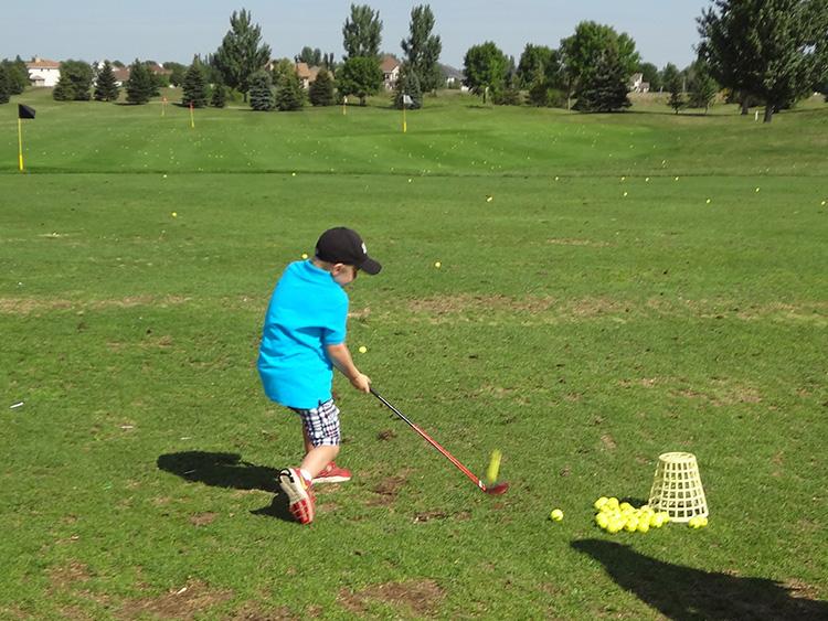 golfyouth3 This image shows a young boy on the driving range during youth golf lessons.