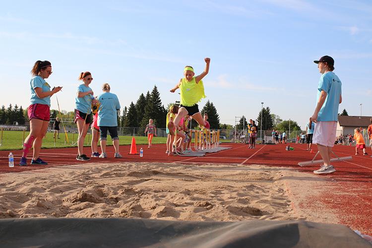 This image shows a girl doing the long jump during the track and field program.