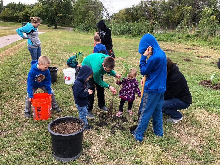 reforestthered2019 This image shows people planting a tree.