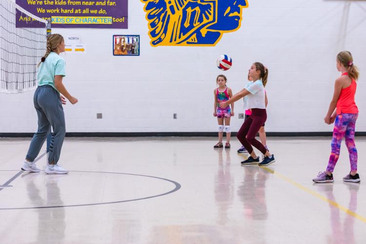 This image shows four girls playing volleyball.