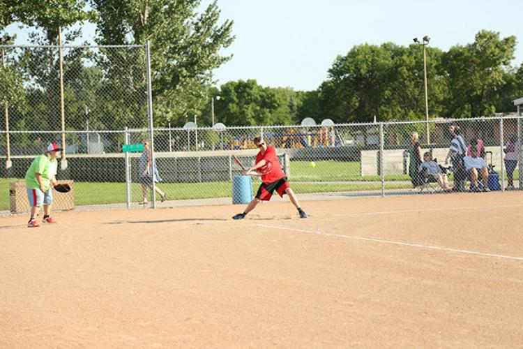 This image shows a male batting during the adaptive softball program.