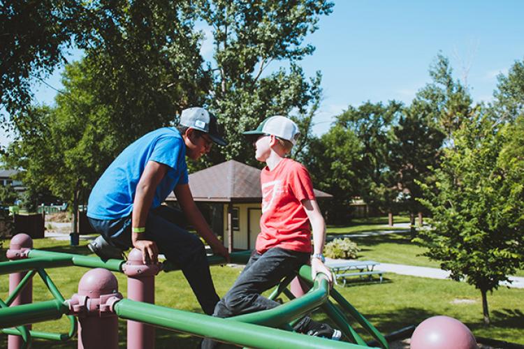 This image shows two boys on the playground during the youth adaptive summer camp.