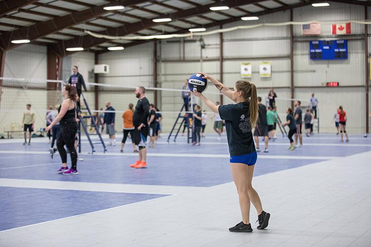 This image shows a female serving a volleyball.
