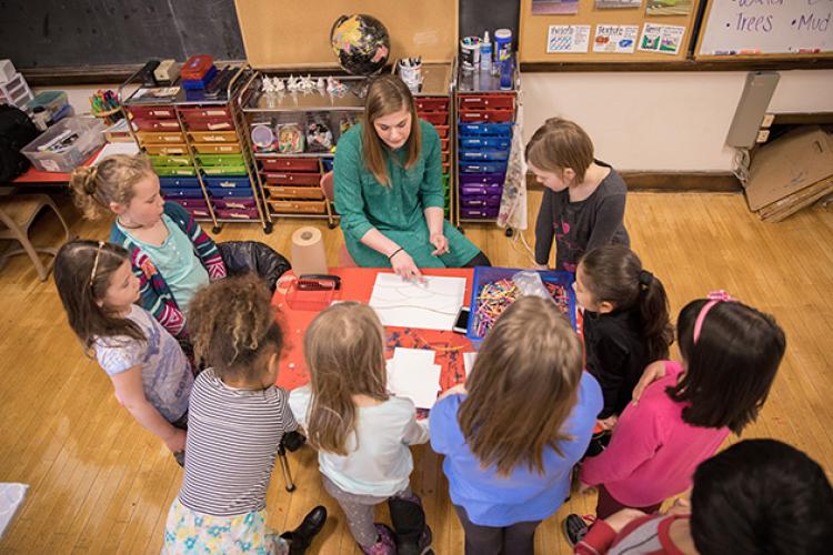 This image shows the instuctor showing kids what to do during the art class.