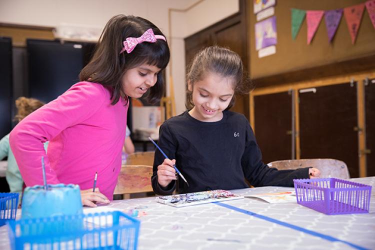 This image shows two girls working on their projects during an art class.