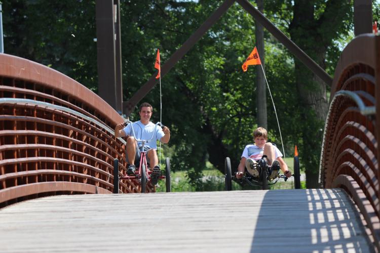 This image shows two kids riding bikes across the bridge at Lindenwood Park