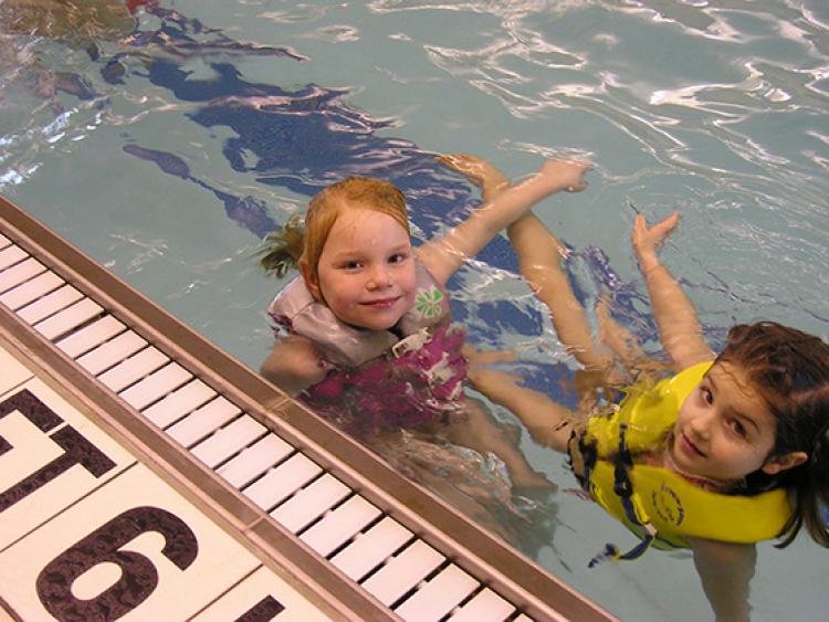 This image shows two girls in the pool at Open Swim.