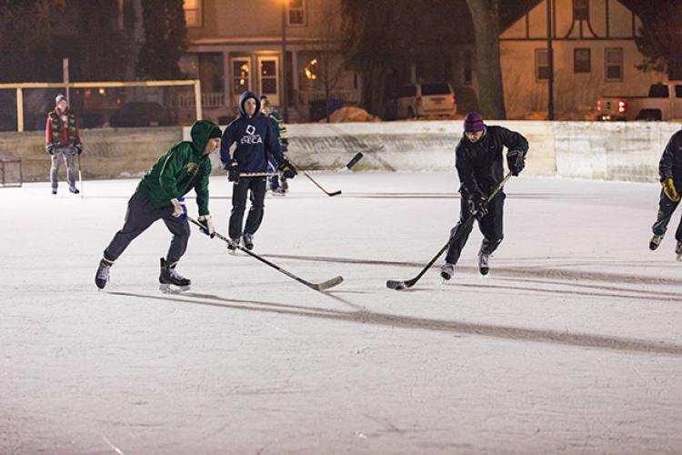 This image shows a game of hockey happening on an outdoor rink.