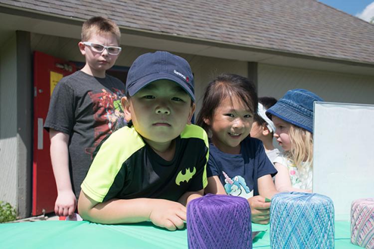 This image shows two kids smiling for the camera during a yarn project at Park It.