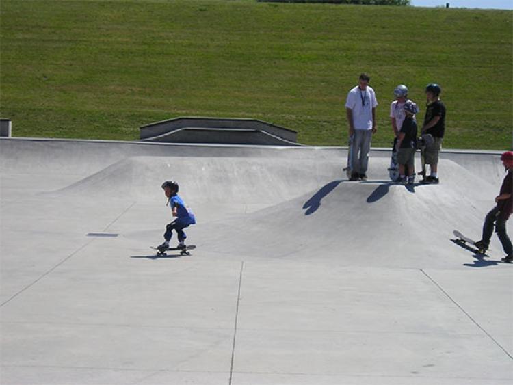 This image shows a young boy skateboarding at the skate park.