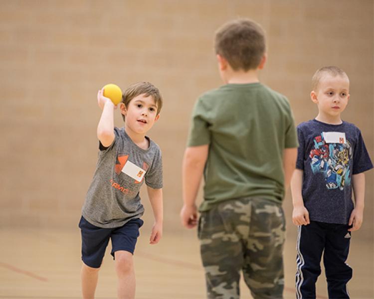 This image shows two boys playing catch at sports sampler.