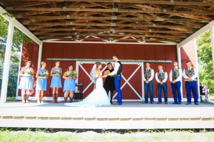 This image shows a wedding ceremony on the barn stage at Trollwood Park.