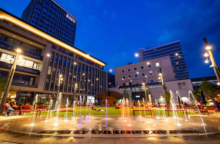 This image shows Broadway Square with the spouts on at night.