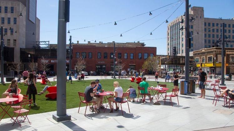 This image shows people enjoying Broadway Square during a sunny, summer day.