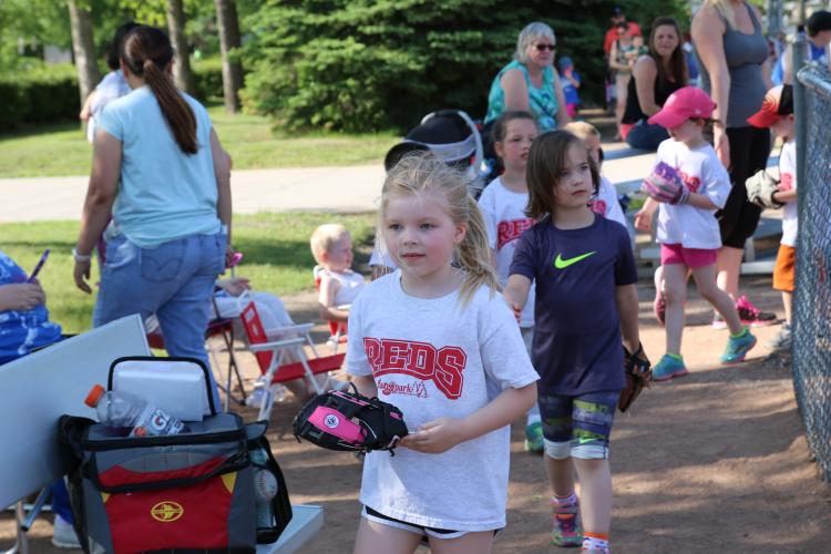 kids walking off the baseball field with their gloves in hand