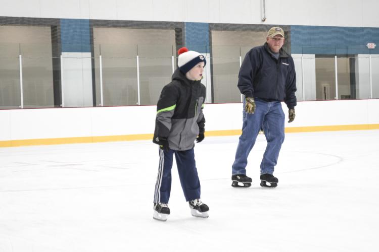 OpenSkate9 Young boy skating indoors at the Coliseum with an older male skating behind