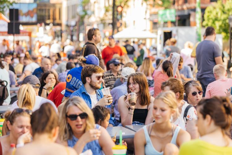 Large crowd with focus on couple drinking at the Downtown Fargo Street Fair