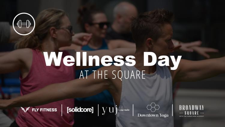 This photo shows people doing a yoga class at wellness day at wellness at the square 2024 with partner logos like solidcore, fly fitness, yuj yoga and downtown yoga fargo