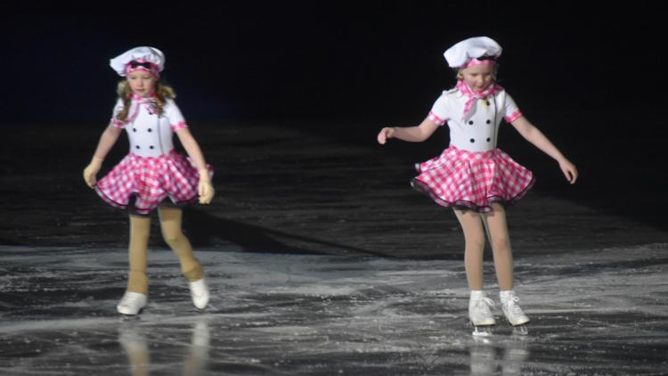 two girls in pink and white chef outfits ice skating to a routine for the Fargo Parks Ice Revue