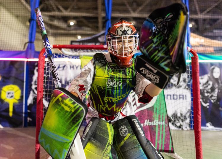 Child in goalie gear standing in front of goal for NHL Steet