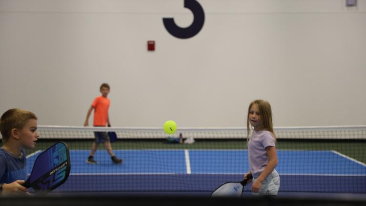 two boys and one girl playing pickleball on the Fargo Parks Sports Center pickleball courts