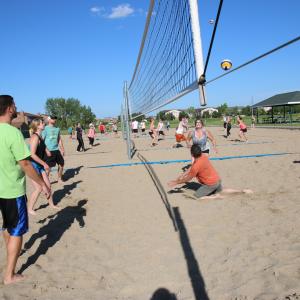 This image shows a sand volleyball match being played. 