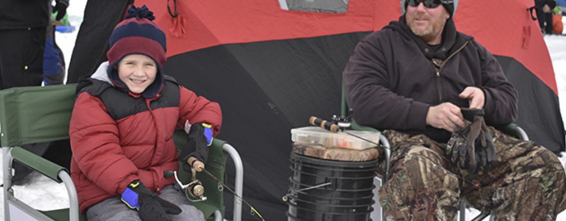 This image shows a dad and his son at the Youth Ice Fishing Derby.