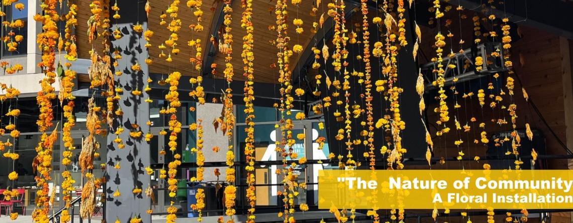 picture of yellow flowers hanging from pavilion at Broadway Square, white text that says The Nature of Community a floral installation