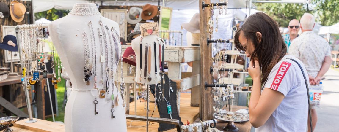 woman looking at jewelry at Island Park Show booth