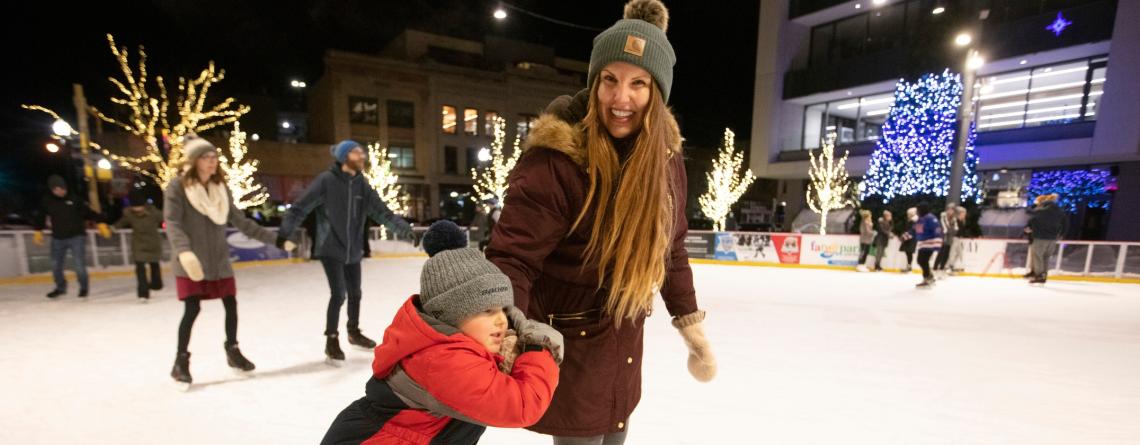 Woman and child skating in outdoor rink