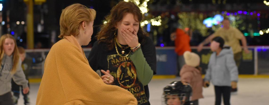 Two girls laughing and skating at Broadway Square