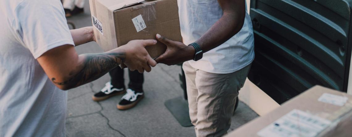 This image shows someone dropping off donations for Day of Dignity like toothpaste, lotion, and deodorant
