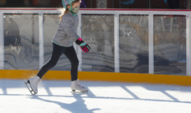 This image shows a young girl skating on the rink at Broadway Square.