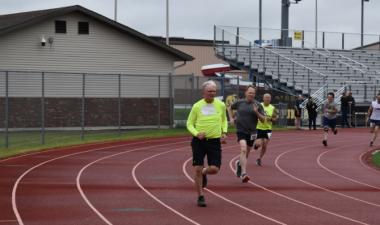 three men running in track event