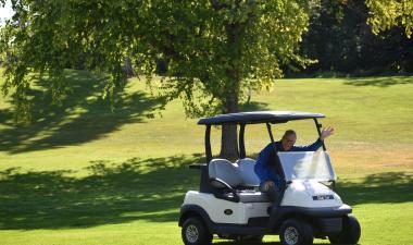 man in golf cart waving