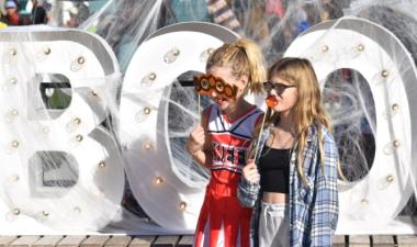 Two girls pose in front of Boo sign