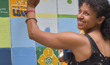 Photo of woman painting community mural
