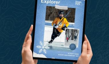 Hands holding a tablet with the cover of the Fall-Winter Activity Guide. 