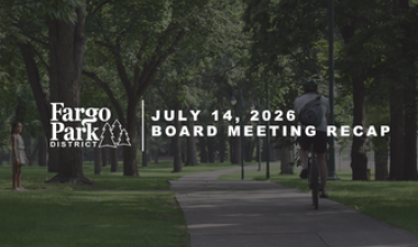 Fargo Park District July 14, 2026 Board Meeting Recap graphic featuring a shaded park pathway lined with mature trees and people walking in the background. 