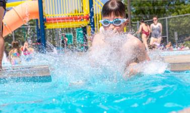 boy cannon balling in pool.