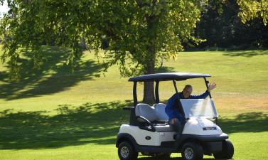 man in golf cart waving