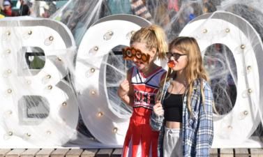 Two girls pose in front of Boo sign