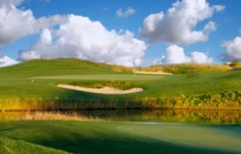 This image shows some water, sand and a green on a hole at Osgood Public Golf Course.