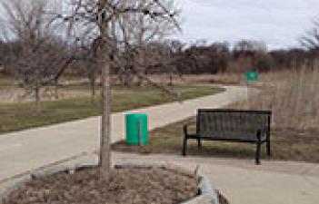 This image shows a bench by the trail at Wildflower Grove Park.